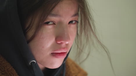 어린 소녀의 눈물을 흘리는 얼굴의 클로즈업, 약간 망진창의 머리카락과 깊은 우울한 표정, 그녀의 눈은 아래로 던져, 우려와 성찰의 상태를 반영합니다.