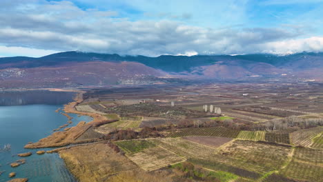 Flying-over-agricultural-fields-and-the-calm-waters-of-lake-Vegoritida-in-Macedonia-province,-Greece