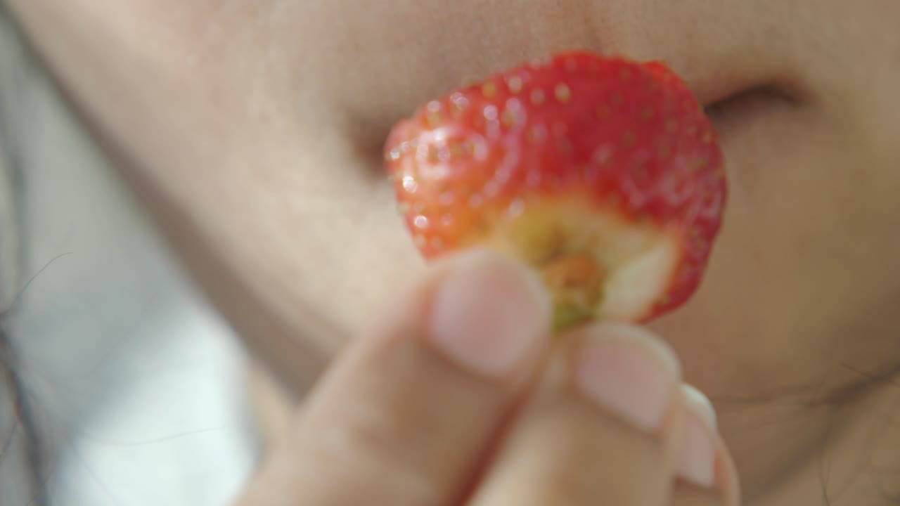 Person eating a strawberry