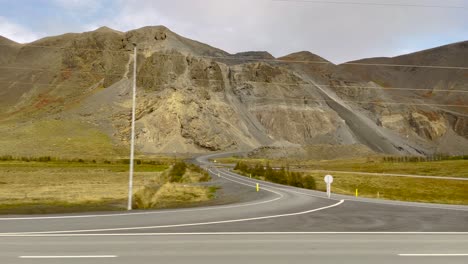 rugged icelandic landscape with mountains, road view from moving car, cloudy day