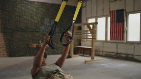 woman in military uniform doing suspension training exercises