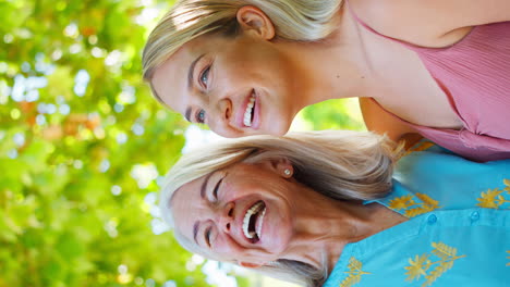 vertical video of multi-generation family with senior mother and adult daughter laughing in garden