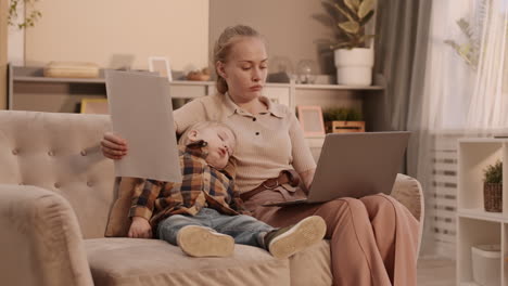 mother working near sleeping son