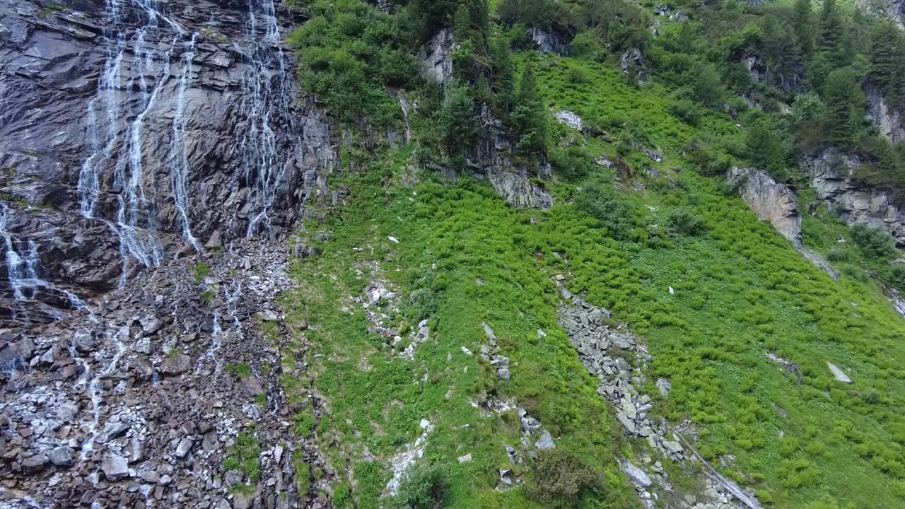 el agua cae graciosamente por la ladera de la montaña cubierta de rocas.