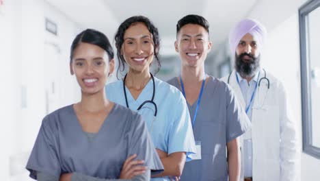 portrait of diverse doctors and nurses smiling in corridor at hospital, in slow motion