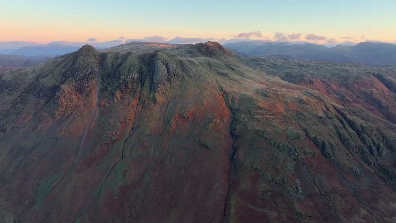 Mountain peaks catching winter dawn light on a clear morning. Langdale Pikes, English Lake District, Cumbria, UK.