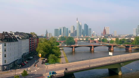 view of frankfurt city skyline by the main river with daytime traffic on road bridges in frankfurt, germany