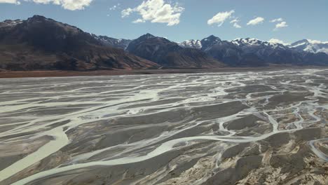 Epic-aerial-view-of-Tasman-river-delta-flowing-into-turquoise-Lake-Pukaki