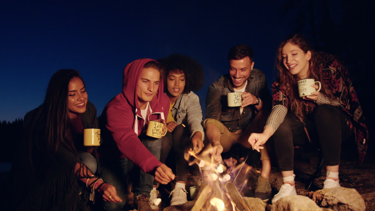 친구 들 이 캠프 불 에서 마쉬멜로 를 즐기고 있다