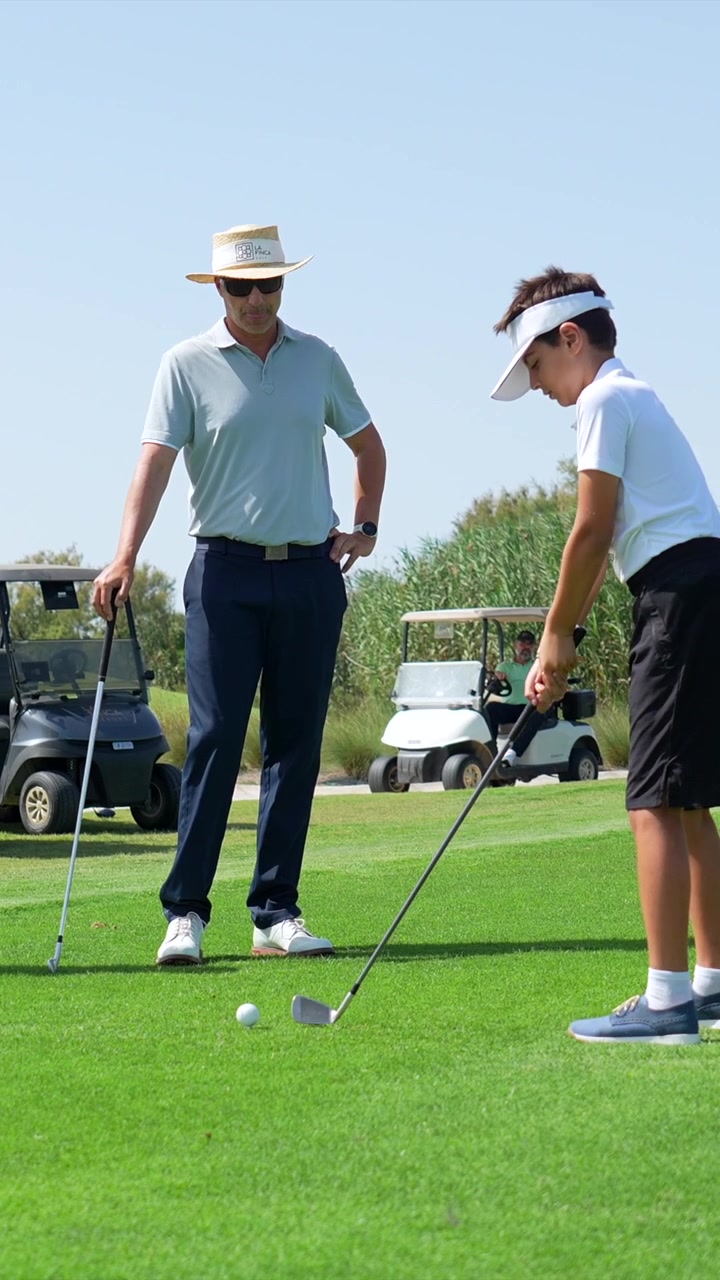 Father Teaching His Son How to Play Golf on a Sunny Day