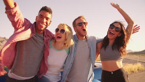 friends on road trip standing by convertible car shot on r3d