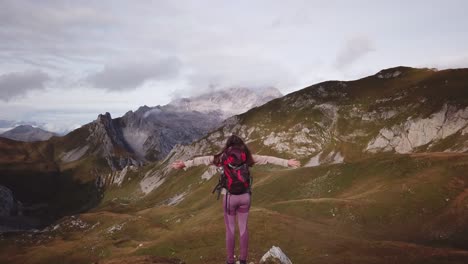 mujer está de pie en los alpes - vuelo rápido de drones de paralaje inverso