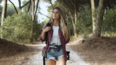 chica de trekking caminando por el sendero del bosque para acampar