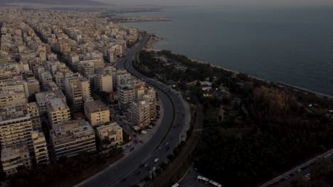 aerial view of flisvos seaside neighborhood of athens, traffic and buildings at twilight, drone shot