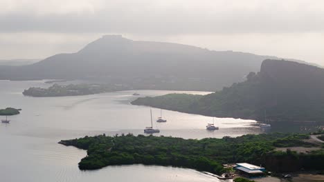 Katamaran-Verlässt-Spanische-Gewässer-Bei-Sonnenaufgang,-Dahinter-Der-Tafelberg,-Curacao