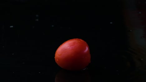 Tomates-Cherry-Cayendo-En-Un-Charco-Negro