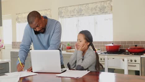 padre hablando por teléfono móvil mientras la hija está sentada al lado en la cocina 4k