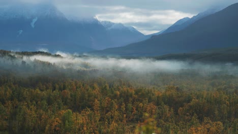 Dünner-Nebel-Kriecht-über-Das-Bergige-Tal,-Während-Die-Sonne-Aufgeht-Und-Die-Landschaft-Erhellt