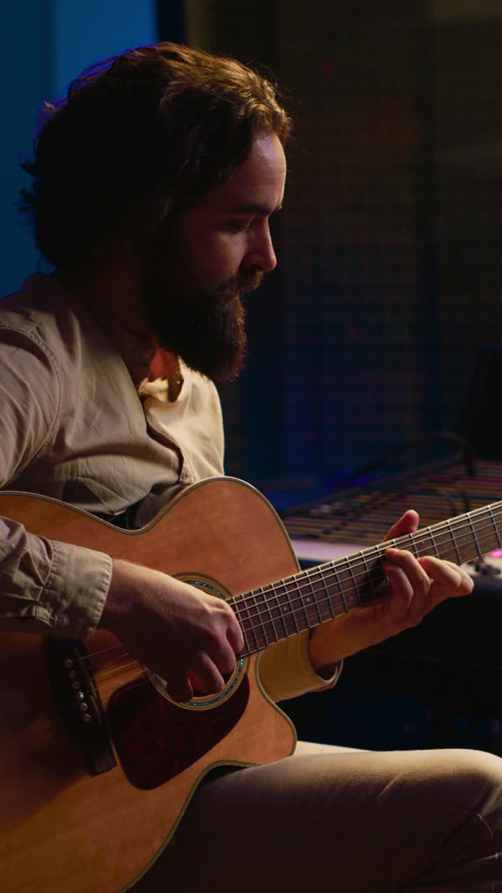 Hombre tocando la guitarra acústica en un estudio de música