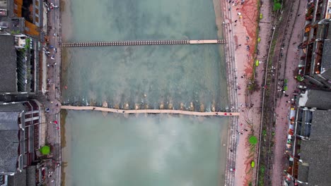 Wooden-Bridge-and-Stepping-Stones-at-Tuo-Jiang-connecting-Phoenix-Ancient-Town-sides,-Fenghuang,-China