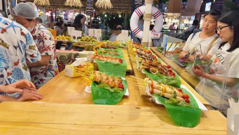 food stall with various skewers at a market