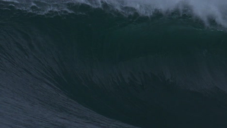 detailed texture view of ocean wave lip curling as mist rises off top