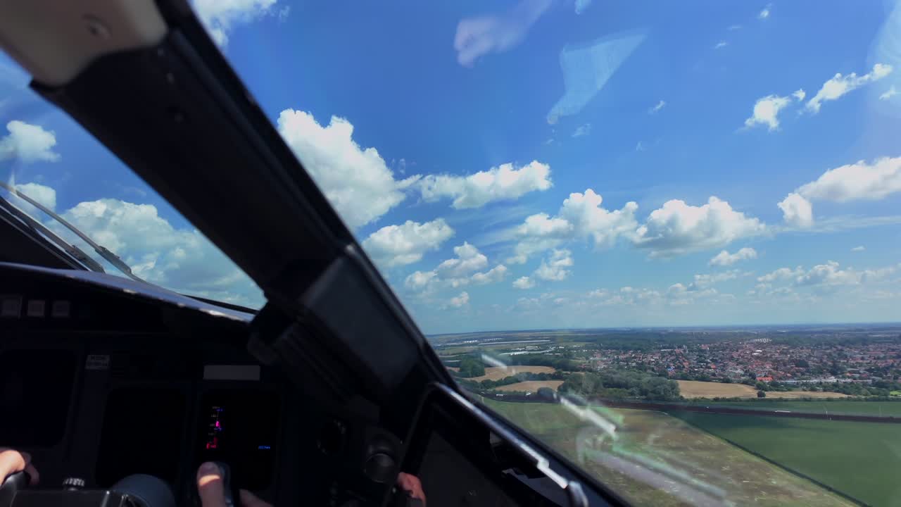 Cockpit view: hand of a pilot handling manually the flight controls in a real time takeoff and initial climb from a short runway, under a blue sky with scattered clouds
