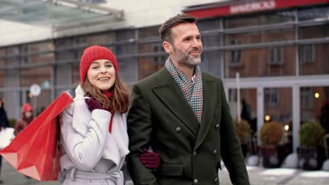 mature couple with shopping bags walking the street