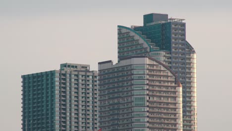 Modern-Architectural-Exterior-Design-Of-Highrise-Buildings-In-Tokyo,-Japan-Against-The-Clear-Sky---zoom-in-shot