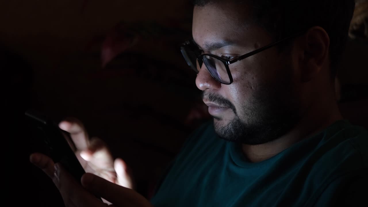 hombre usando teléfono inteligente por la noche