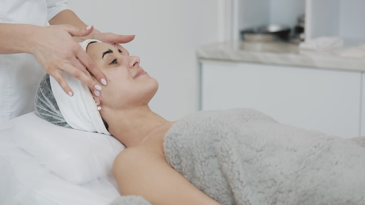 mujer recibiendo un masaje facial en un spa