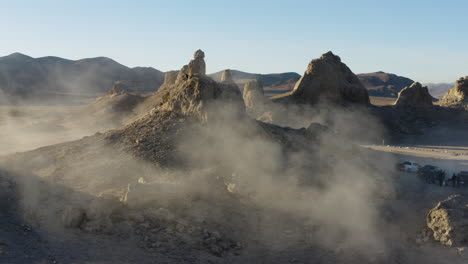 Aerial-shot-of-a-large-pinnacle-overshadowing-a-camping-site-in-the-california-desert