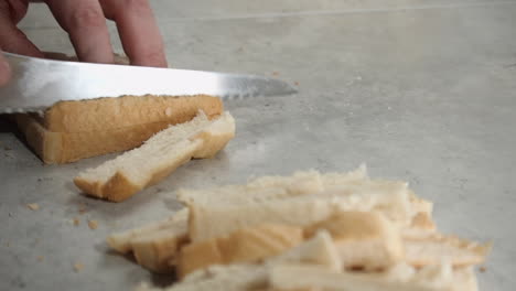 Cook-cuts-crusts-off-slices-of-white-bread-with-serrated-knife