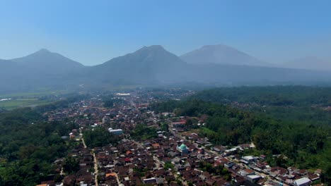Scenic-aerial-panorama-of-Grabag-village-and-three-volcanoes,-Java,-Indonesia