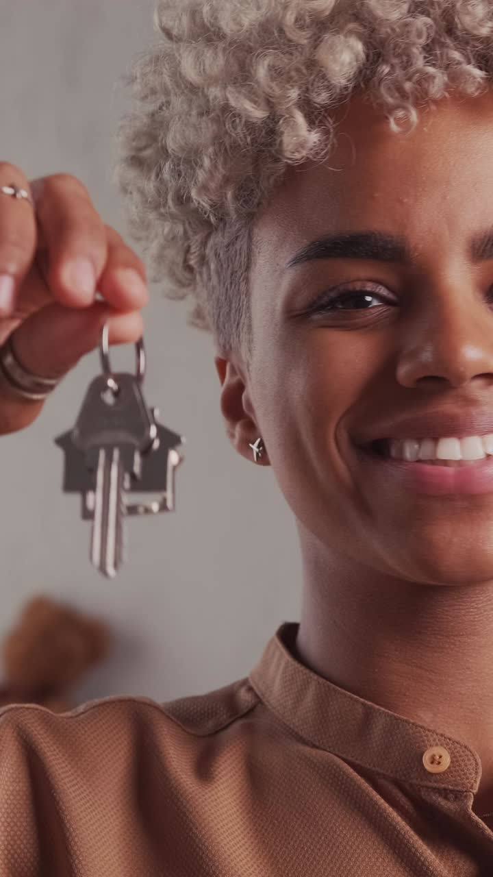 Young smiling african american woman realtor shows keys to house