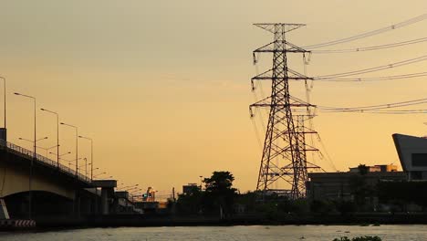 Hochspannungsleitung-An-Der-Seite-Des-Flusses-Während-Des-Sonnenuntergangs