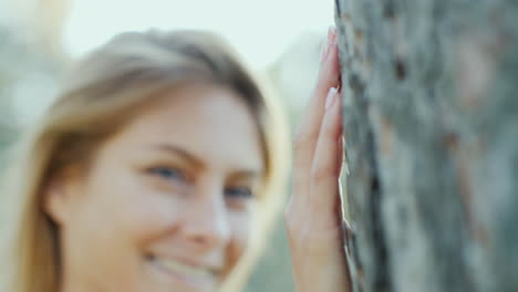 Porträt-Einer-Schönen-Jungen-Frau,-Die-Am-Baum-In-Der-Sonne-Steht-und-Lächelnd-In-Die-Kamera-Schaut