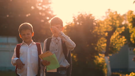 kids in school uniform with bags stand holding books