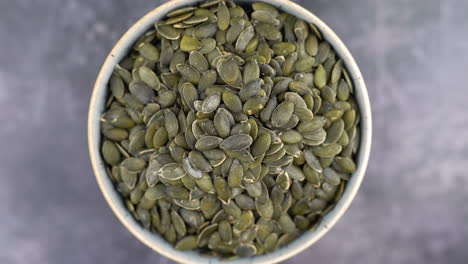 healthy organic pumpkin seeds, macro close-up of pumpkin seeds in bowl, healthy vegetarian vegan raw food