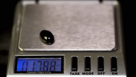 weighing a black gemstone on a digital scale