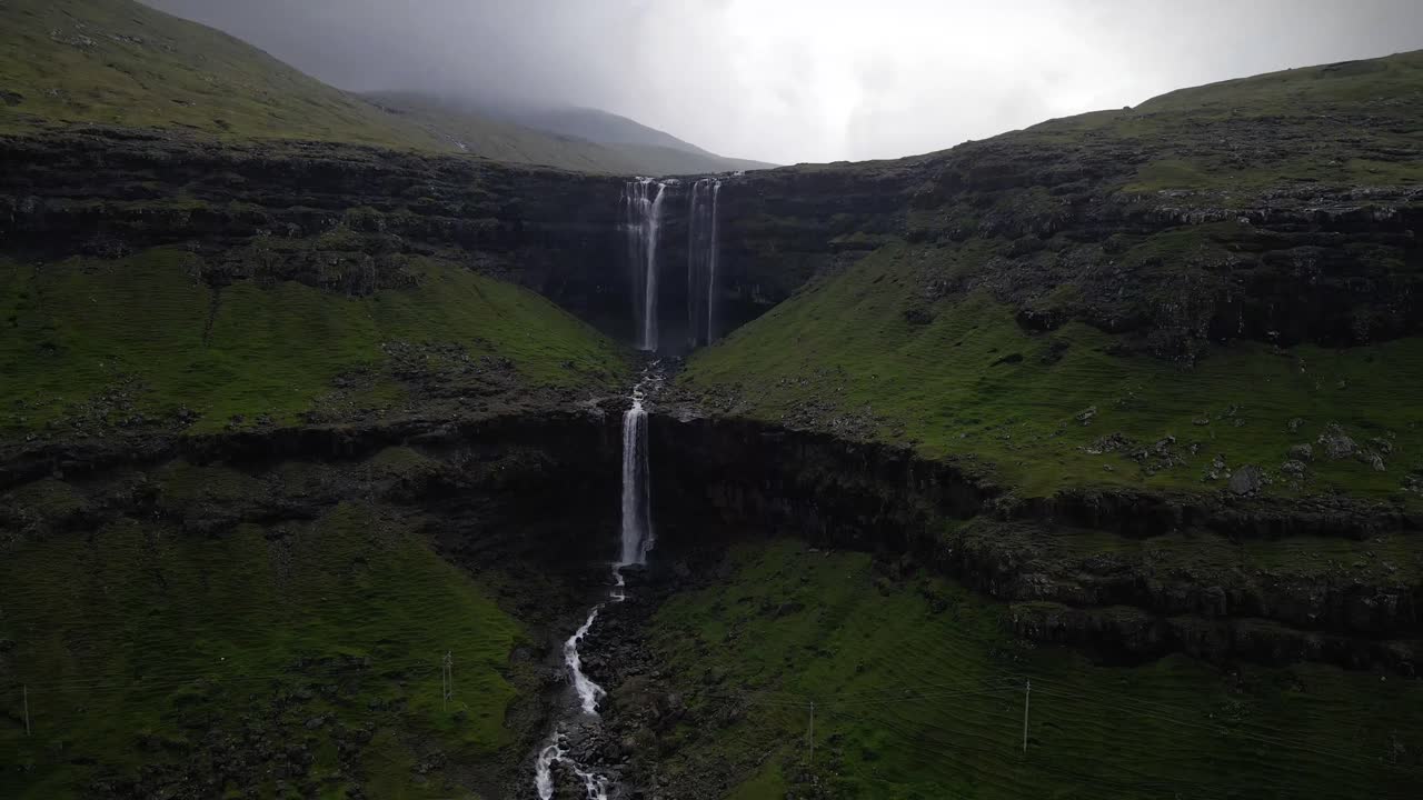 la cascada de fossa, la más alta de las islas feroe, fluye a través de espectaculares acantilados y exuberante vegetación, cayendo en cascada en una serena cuenca de agua. un sorprendente punto de referencia natural en un impresionante paisaje nórdico