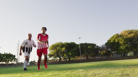 video of diverse group of male football player on field, playing football