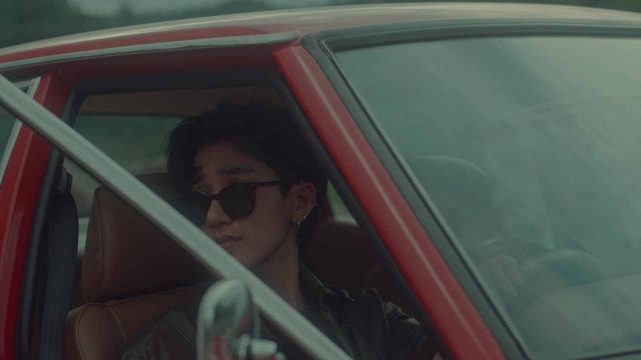 Man Driving a Vintage Red Car