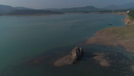 close up view of ancient remains of a stone carved hindu temple submerged underwater. circular aerial motion. bilaspur, himachal pradesh incredible india
