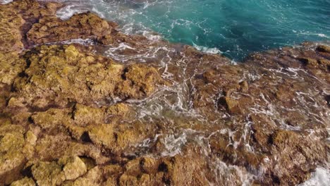 rocky coastline and foamy ocean waves near tenerife island, aerial view