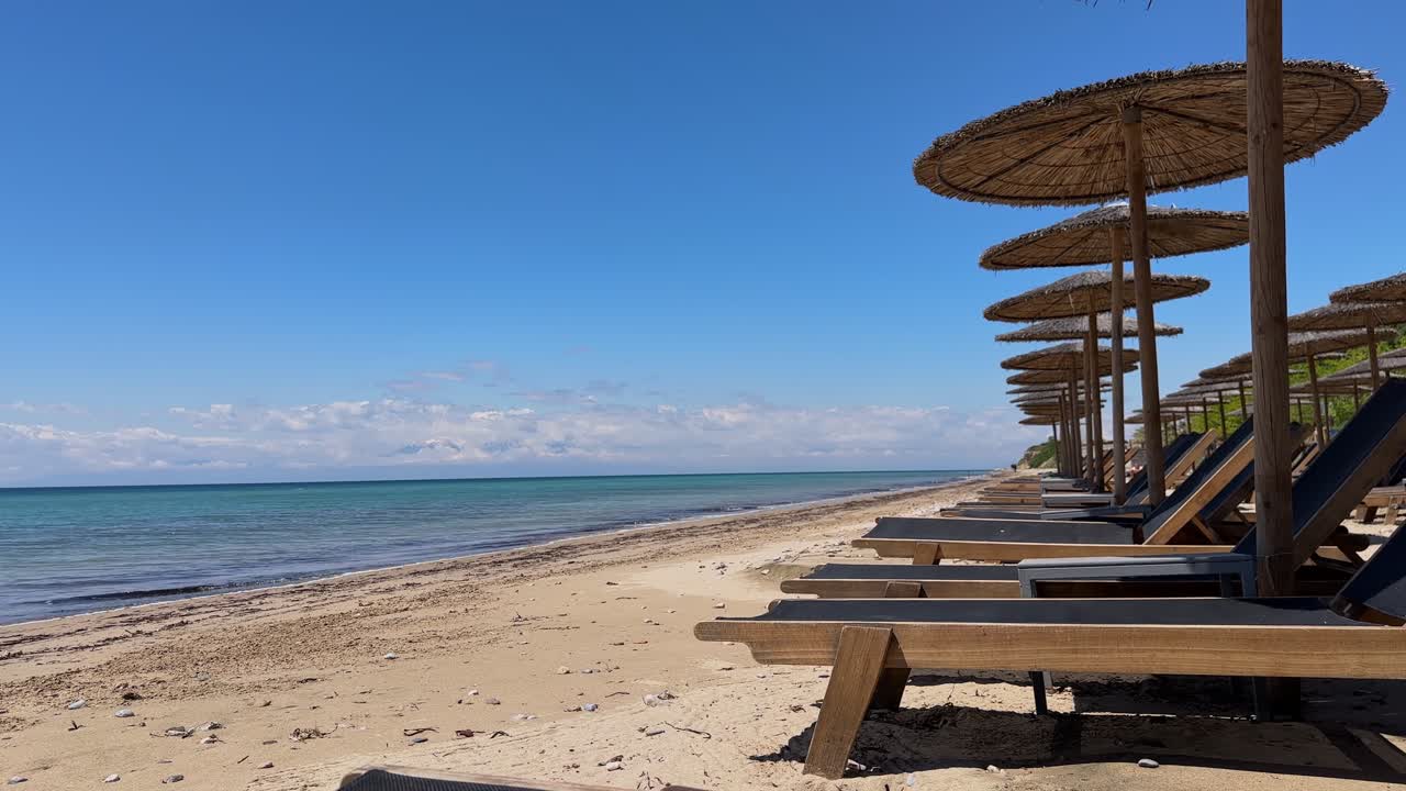 Stunning beach scene in Halkidiki, Greece, with elegant sunbeds facing the crystal-clear turquoise sea. A perfect summer escape in the heart of the Aegean.