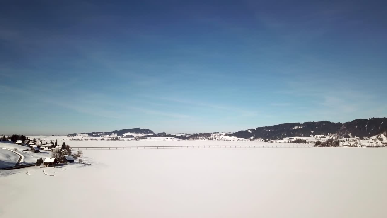 다리는 스위스의 눈 덮인 호수 위로 이어집니다