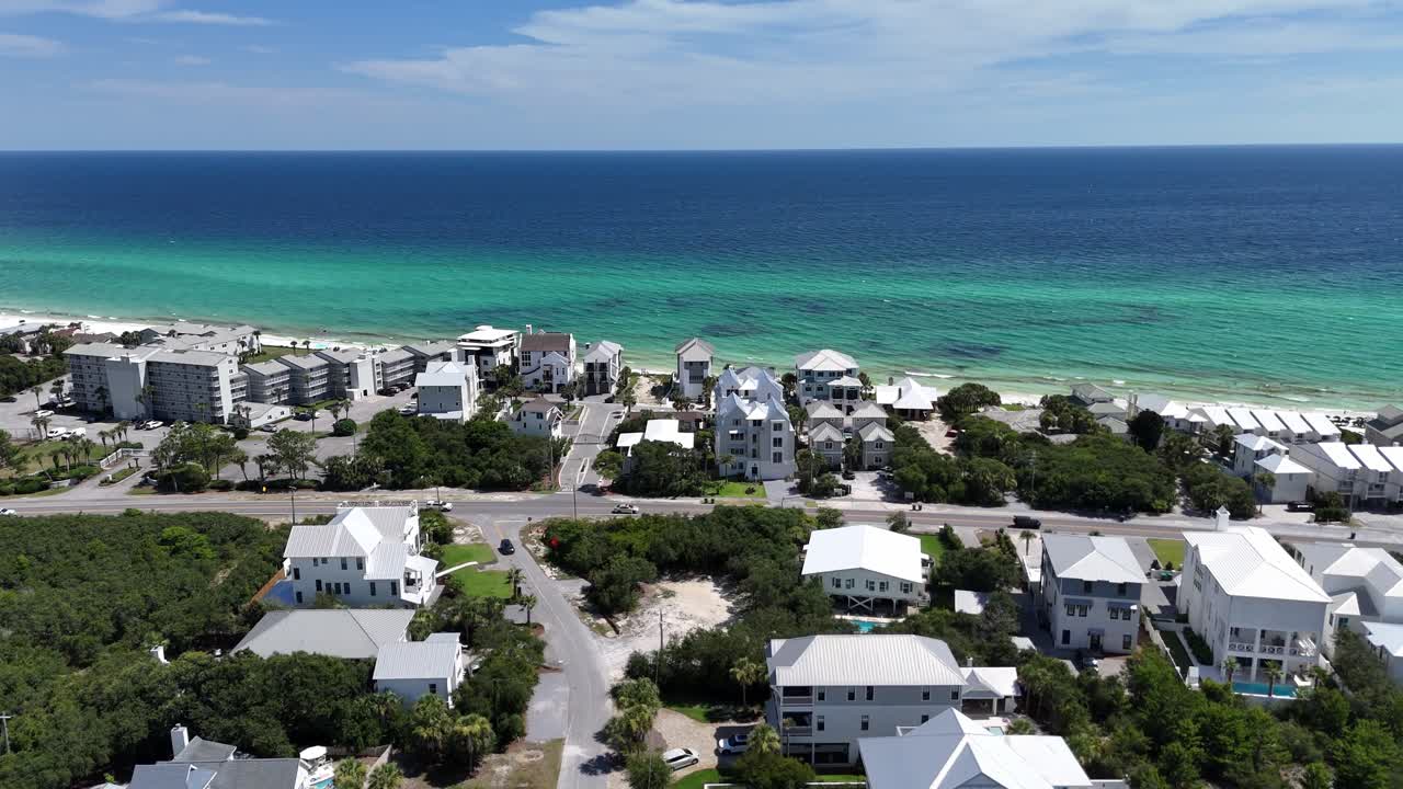 Forwardly upwards drone movement over the coastal luxury residential and suburban area overlooking turquoise water, 30A, Florida, USA