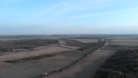 Vista-Aérea-De-Los-Camiones-Pesados-Que-Viajan-Por-La-Carretera-Rural-En-El-Campo