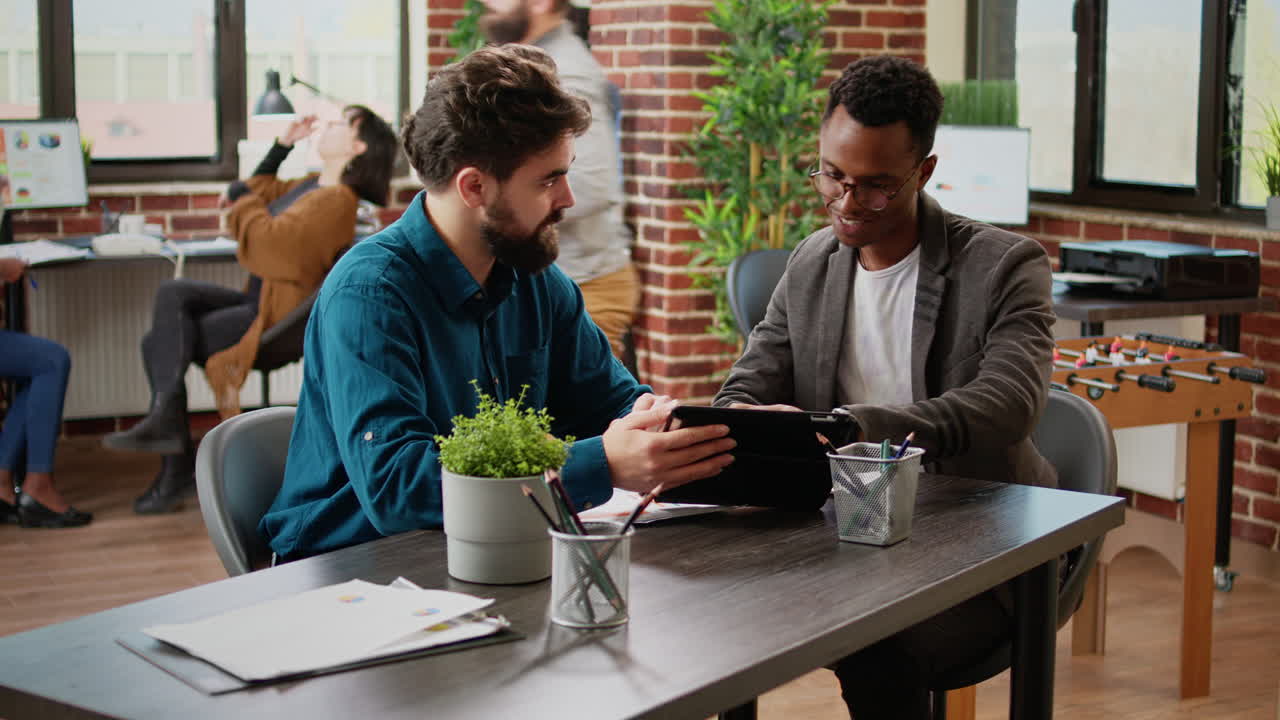 Diverse team of business people analyzing report on digital tablet